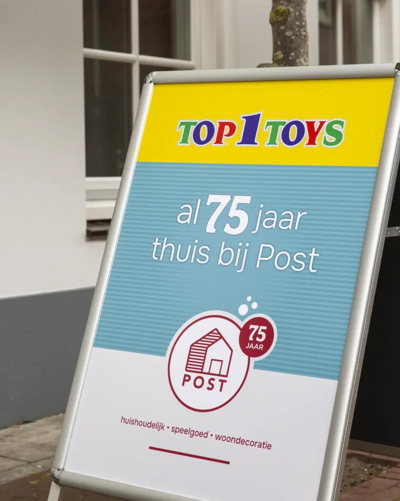 Stoepbord van Top 1 Toys en Warenhuis Post: al 75 jaar thuis bij Post